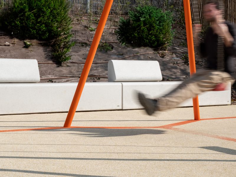 Man swinging in a Paris park with street furniture from Durbanis