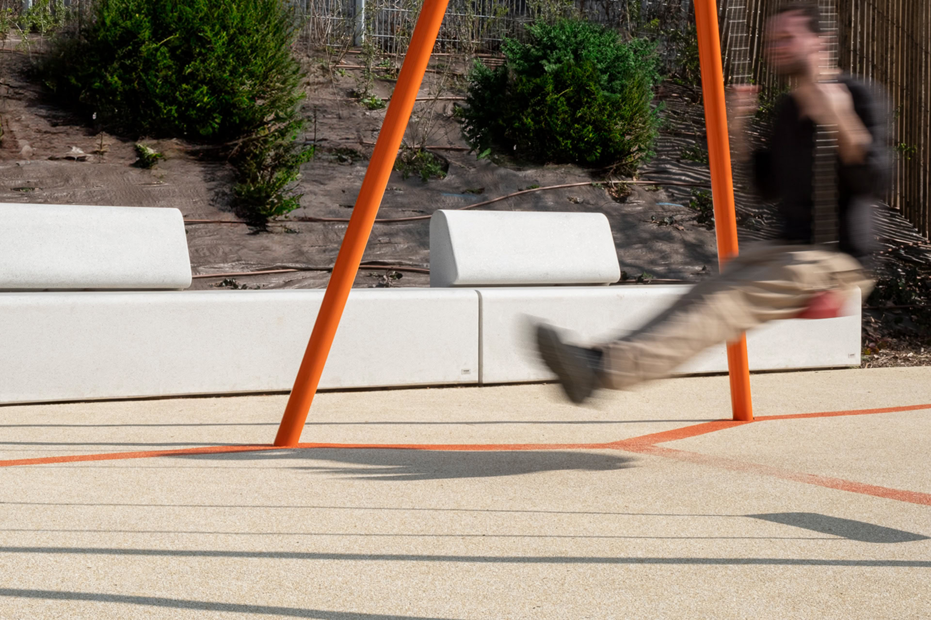 Man swinging in a Paris park with street furniture from Durbanis