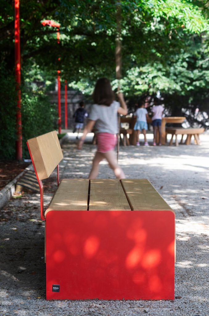 Soka Parkea furnished with outdoor benches with backrests, made of wood and colored veneer